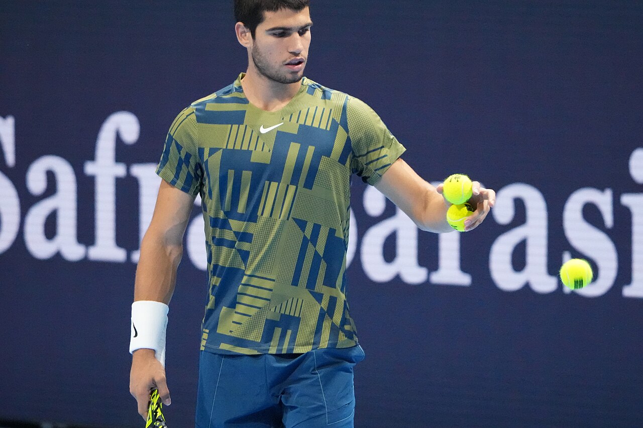 Tennisser met ballen in de hand voor de opslag