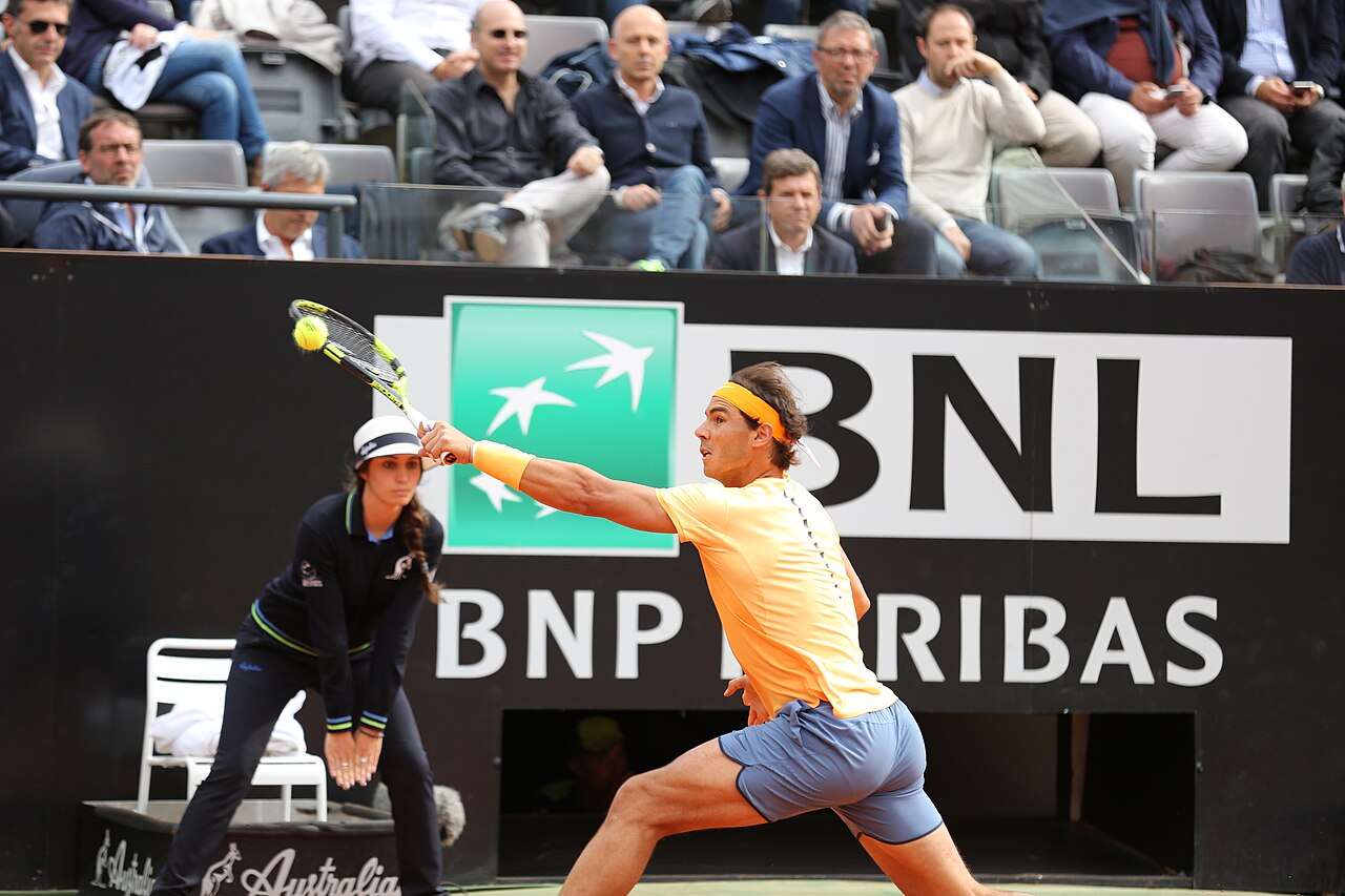 Speler strekt zich ver uit voor een forehand langs de zijlijn